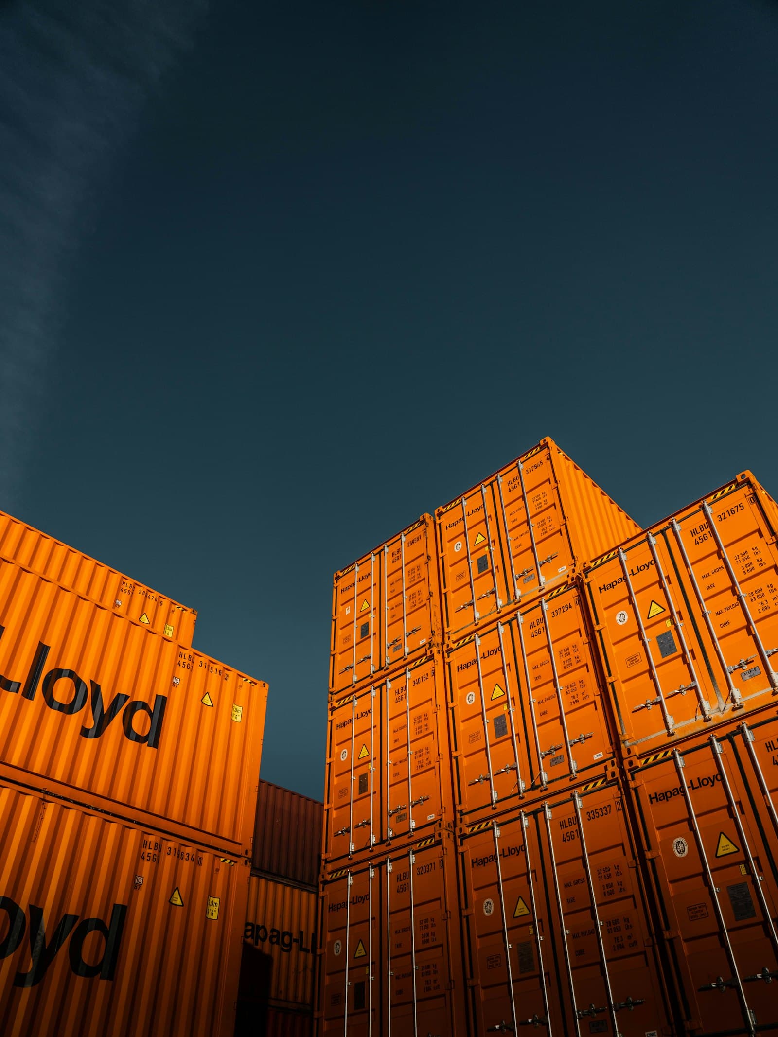 Stacked shipping containers against a blue sky