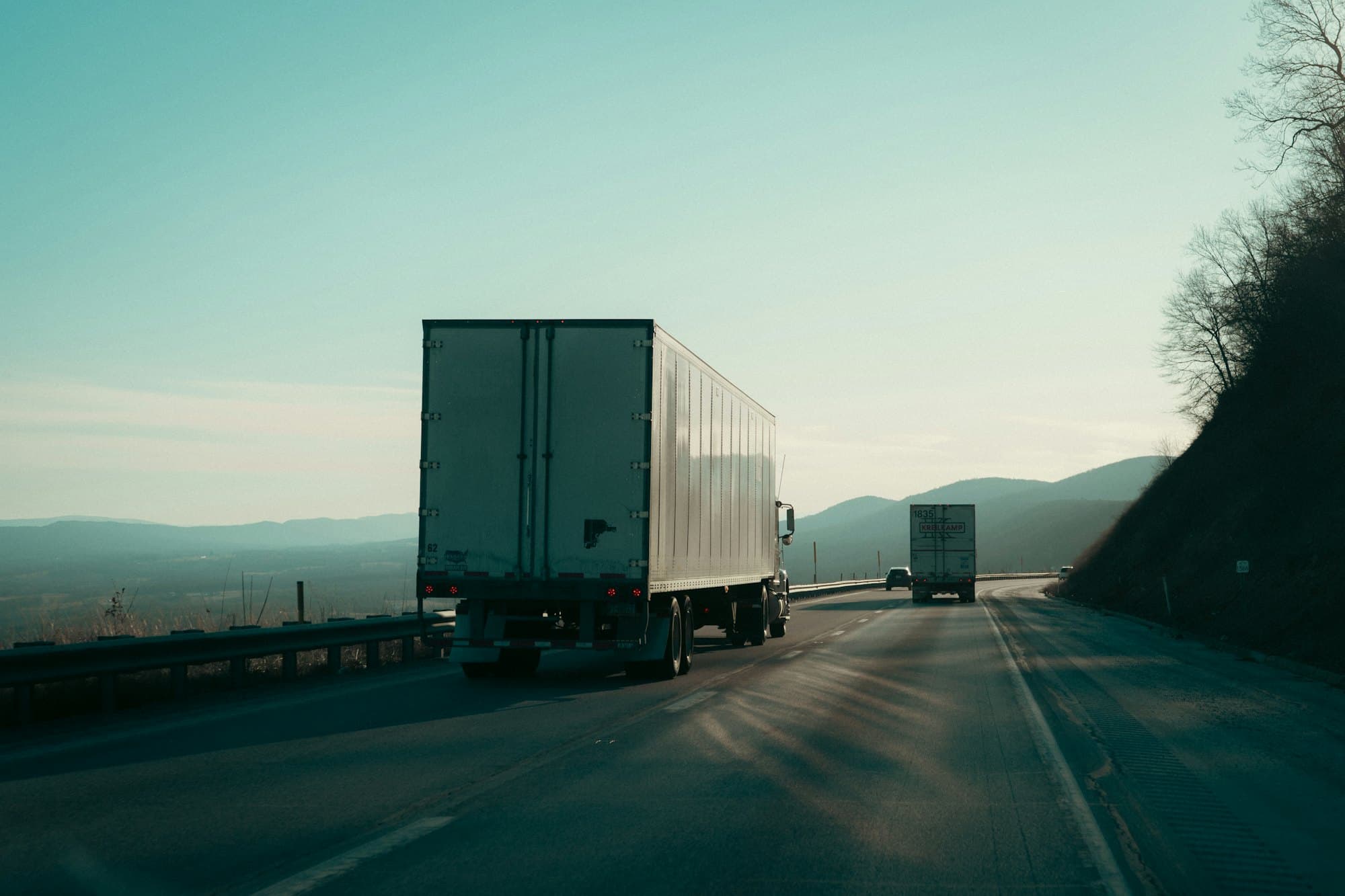 Freight trucks on a highway at dusk